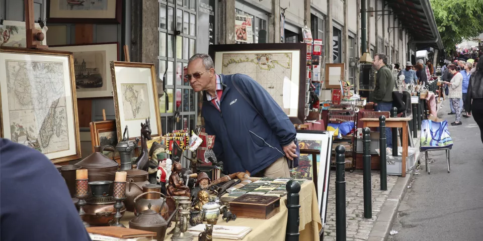 Hombre mirando un puesto en el Mercado de Santa Clara de Lisboa